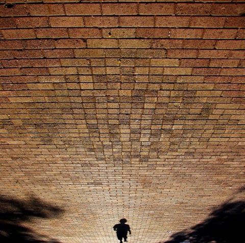 walking shadow on a brick sidewalk
